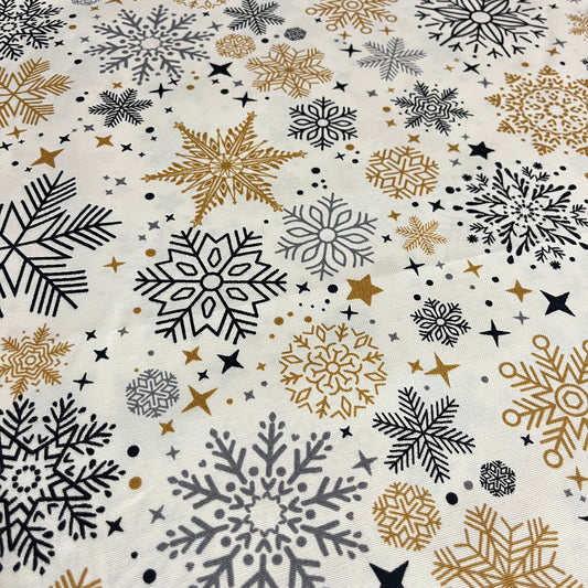 Toile déperlante de Noël flocons or et noir sur fond blanc, gros plan sur les flocons dorés et noirs - MyTissus