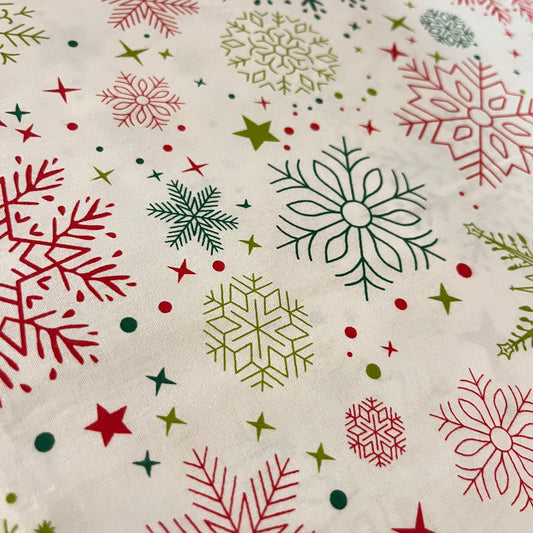 Tissu de Noël flocons de neige rouges et verts sur fond blanc, popeline de coton 240 cm, gros plan sur les flocons - MyTissus