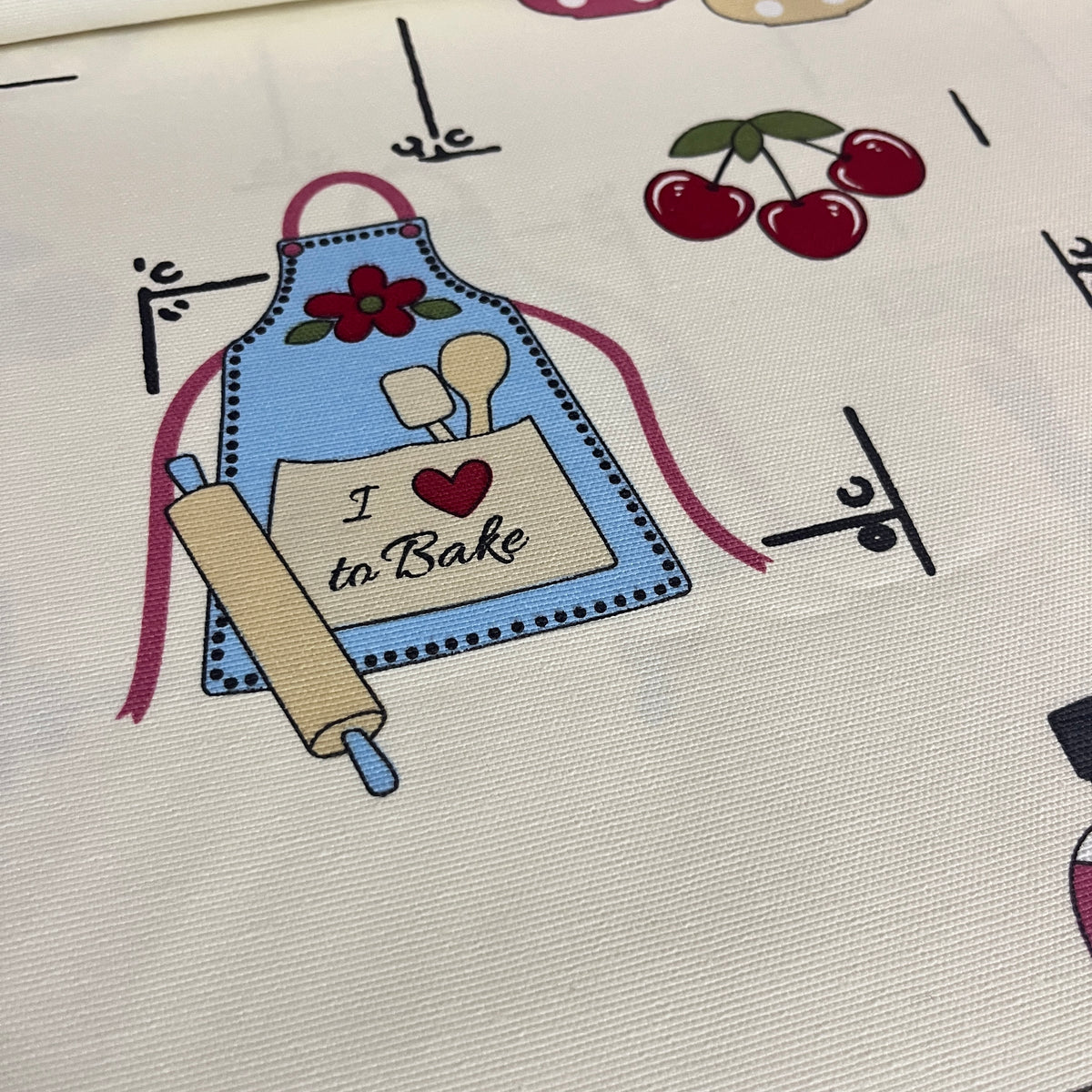 Toile déperlante cuisine rétro I love to bake, gros plan sur le tablier, les ustensiles et les cerises - MyTissus