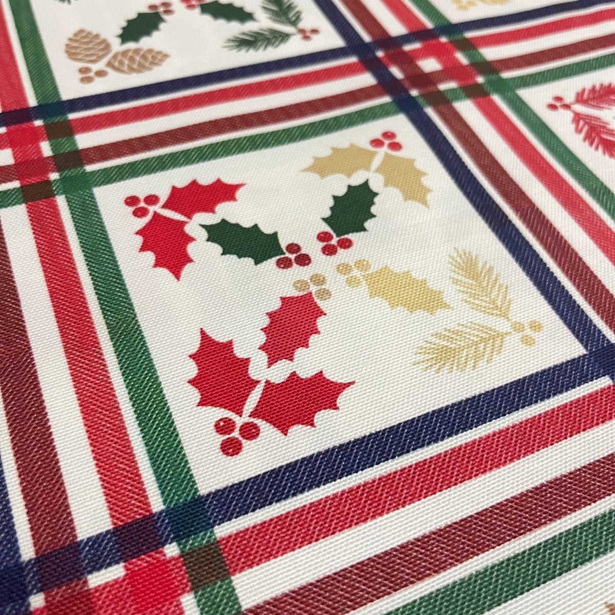 Toile déperlante de Noël carreaux tartan houx et pommes de pin, tissu au mètre plié - MyTissus